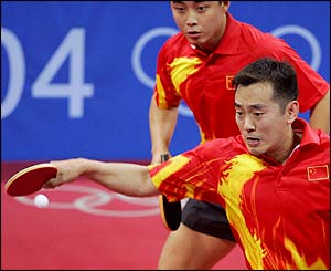 Linghui Kong smaches the ball as partner Hao Wang stands behind