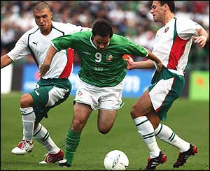 Andy Reid dribbles past two Hungary players