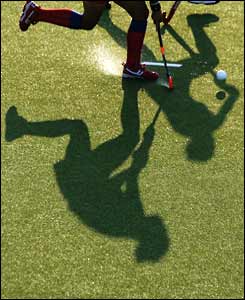 Yun Mi Kim of South Korea runs with the ball and her shadow in the women's field hockey 