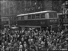 Crowds in front of double-decker bus