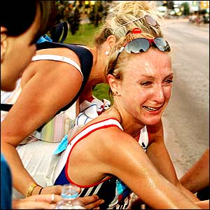 Great Britain's Paula Radcliffe sits on the curb after her withdrawal from the marathon