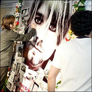 Fans sign messages on a huge poster of Cobain