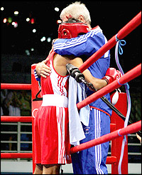 Khan hugs coach Terry Edwards ringside after a rapid victory over his South Korean opponent