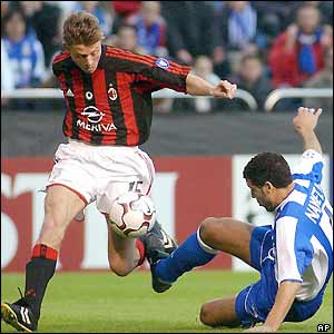 Milan's John Dahl Tomasson is tackled by Deportivo's Naybet