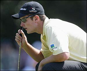 Overnight leader Justin Rose crouches over a putt