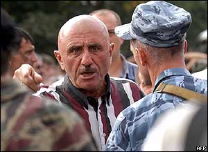 A man speaks to soldiers enforcing an exclusion zone around the school 