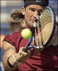 Carlos Moya returns the ball