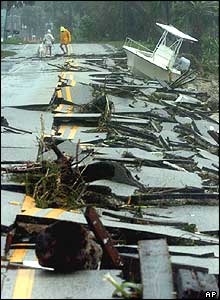 Two dog walkers look at the damage on Indian River Drive in Jensen Beach, Florida