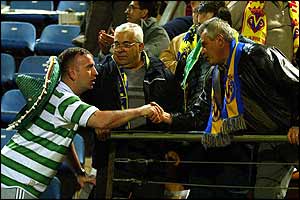 A celtic fan congratulates fans of the other side