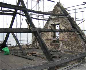 The burnt shell of the building is protected by scaffolding and a giant tented structure