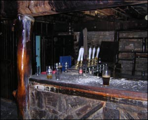Glasses and beer taps stand out amid the gloom of the dark bar 