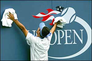 A ball boy wipes down the walls at the US Open