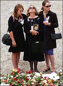 Three women stand at a memorial at Ground Zero 