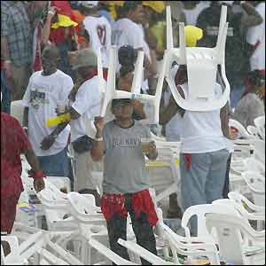 Fans shelter from the rain in Trinidad