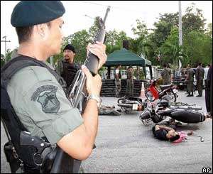 Policeman standing guard over bodies of dead attackers