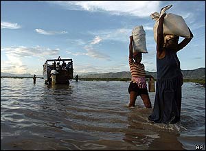 Residents flee their town carrying sacks of rice in Gonaives, Haiti