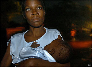 A woman and her baby look for somewhere to sleep after floods in Haiti