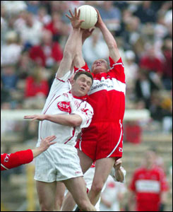 Colin Holmes is outfielded by Derry's Fergal Doherty