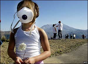 Kiki Kreofski, of Boring, Oregon., holds a flower and wears a dust mask as she stands at the Castle Lake Viewpoint, 2 October 2004