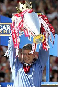 Arsene Wenger lifts the Premiership trophy