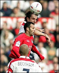 Gary Neville rises to head the ball clear under pressure from his Manchester United team-mate Giggs