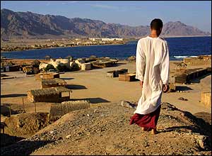 A man in white gallabayah stands overlooking the Ras al-Shitan camps