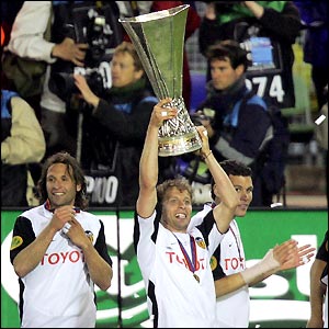 Valencia captain Curro Torres lifts the Uefa cup as his jubilant team-mates start the celebrations