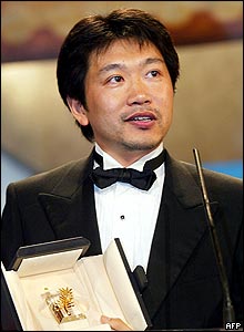 Japanese film director Hirokazu Koreeda accepts the best actor award on behalf of Yagira Yuya for their film Nobody Knows