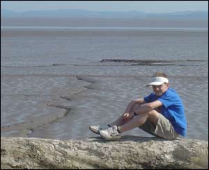 Toby sitting on a log on the foreshore near St Brides in Gwent (John Parker)