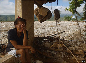 A woman cries next to the remains of her house in Jimani