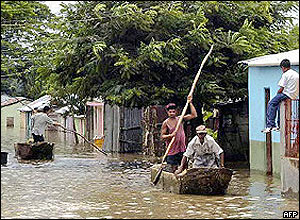 People from the border province of Jimani in the Dominican Republic move along a flooded road