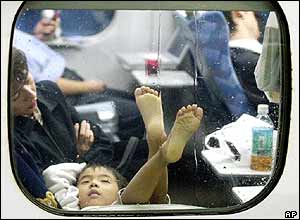 A child lies and places foot up against the window of a bullet train that is stranded at Nagoya station following a powerful typhoon Tokage in Nagoya, Wednesday, Oct 20, 2004