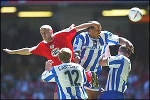 Tony Butler of Bristol City jumps with Brighton's Chris Iwelumo while Richard Carpenter and Guy Butters of Brighton look on
