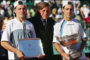 Gaudio saves two match points before receiving the trophy from Guillermo Vilas the 1977 champion