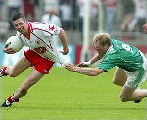 Sean Cavanagh of Tyrone is caught by Liam McBarron