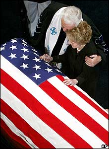 Rev Michael Wenning comforts Nancy Reagan by her husband's coffin
