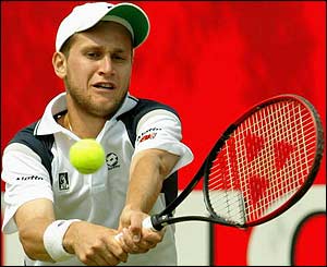 Karol Beck plays a powerful shot to Ivo Karlovic