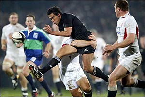 Mils Muliaina kicks through as Lawrence Dallaglio runs for the ball