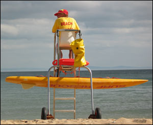 Surf lifeguard in the evening sunshine at Langland Bay, Gower (Jim Young)