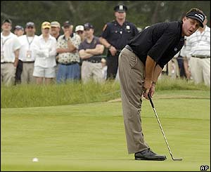Phil Mickelson reacts to a putt on the second