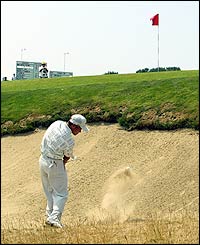 Japan's Shigeki Maruyama plays out of a bunker at the 11th