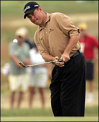 Lee Westwood chips on to the first green