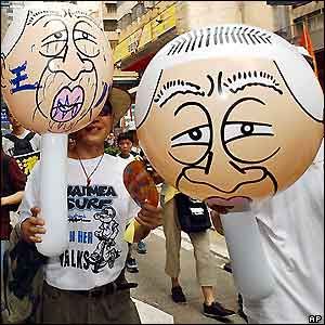 Protesters carry inflatable balloons depicting Hong Kong's Chief Executive Tung Chee-hwa