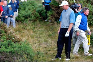 Ernie Els looks quizzically at his ball after ending up in the gorse at the 11th