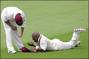 Tino Best feels the pain after a misfield off Strauss deflects onto his cheek 