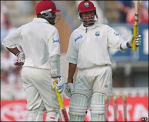 Ramnaresh Sarwan raises his bat as he completes his 50