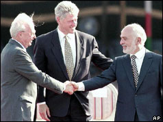 President Clinton smiles as Yitzhak Rabin (L) and King Hussein of Jordan shake hands