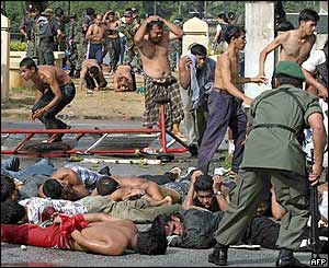 Thai policemen and soldiers arrest demonstrators at Takbai police station in Narathiwat, southern Thailand, 25 October 2004. 