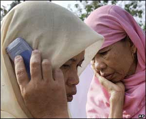 Two women, one calling home, after hearing the news that their family member is dead, Wednesday, Oct. 27, 2004. 