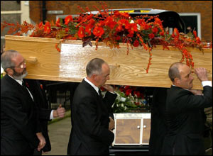 The coffin's arrival and departure was greeted with applause by mourners outside.